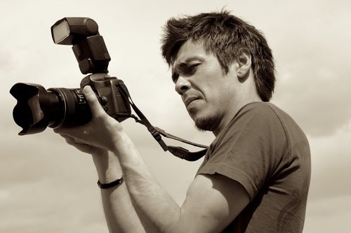 Khasar Sandag holding two cameras while working on assignment